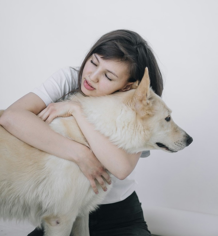 Pet owner hugging a happy dog